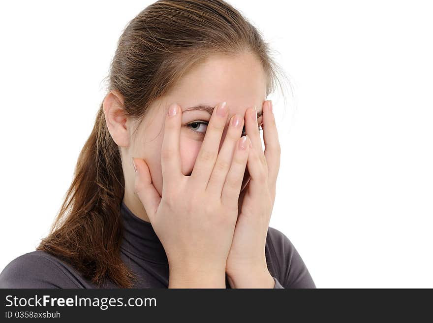 Yong woman hide her face through fingers, on a white background