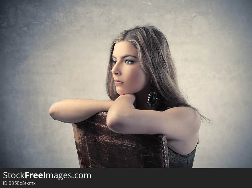 Young beautiful woman sitting on a chair. Young beautiful woman sitting on a chair