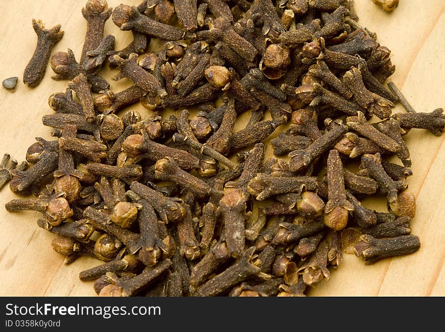 Dried aromatic clove spice on a wooden cutting board. Dried aromatic clove spice on a wooden cutting board