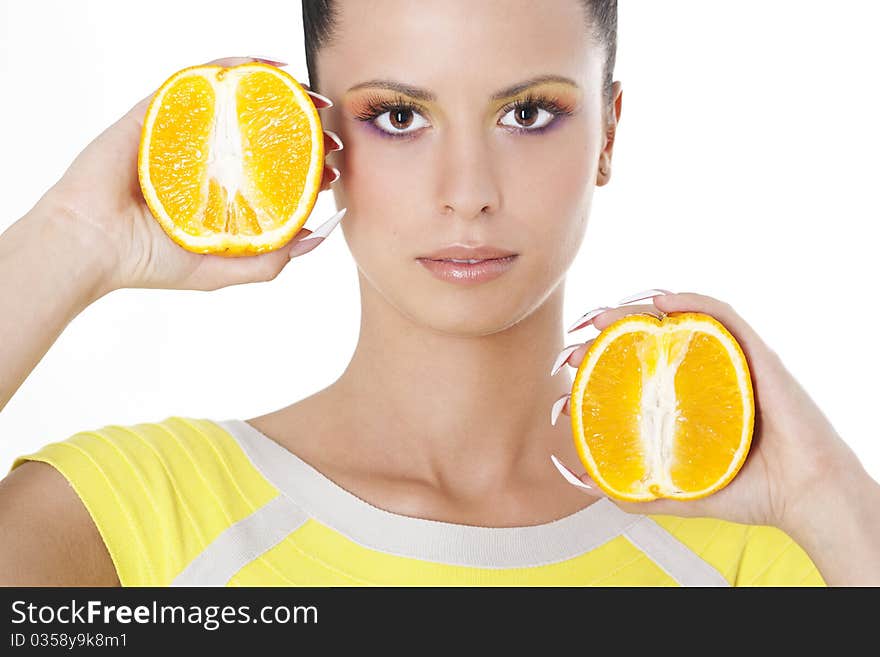 Young beautiful woman holding two halves of orange