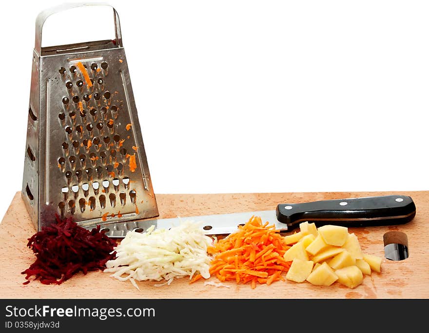 Grated fresh fruits, grater and a knife on a cutting board