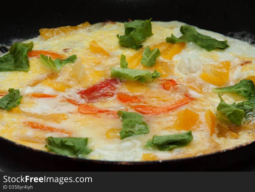 Scrambled eggs with vegetables on a omelet pan