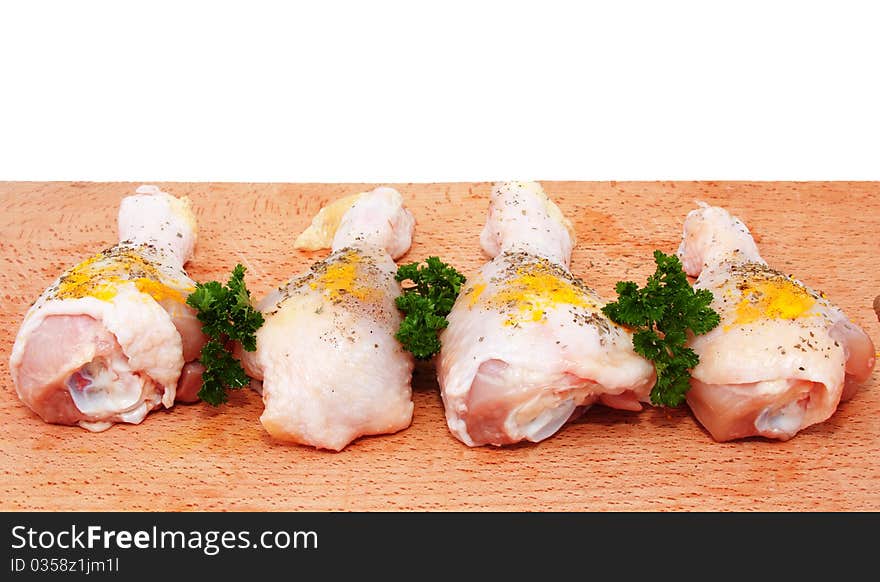 Raw chicken drumsticks with spices on a cutting board. Raw chicken drumsticks with spices on a cutting board