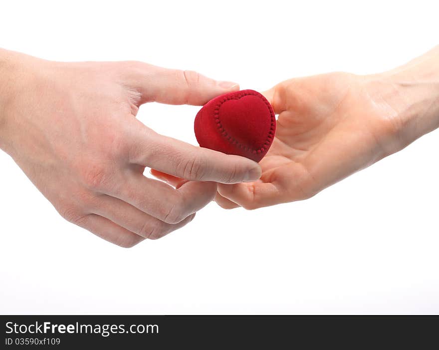 Man's hand expanding red velvet heart-shaped box to woman's hand; isolated on white. Man's hand expanding red velvet heart-shaped box to woman's hand; isolated on white