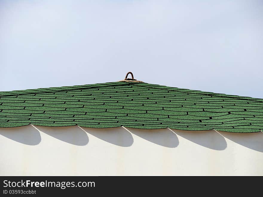 Architectural detail of a colorful roof with patterns of shadow against clear sky. Architectural detail of a colorful roof with patterns of shadow against clear sky