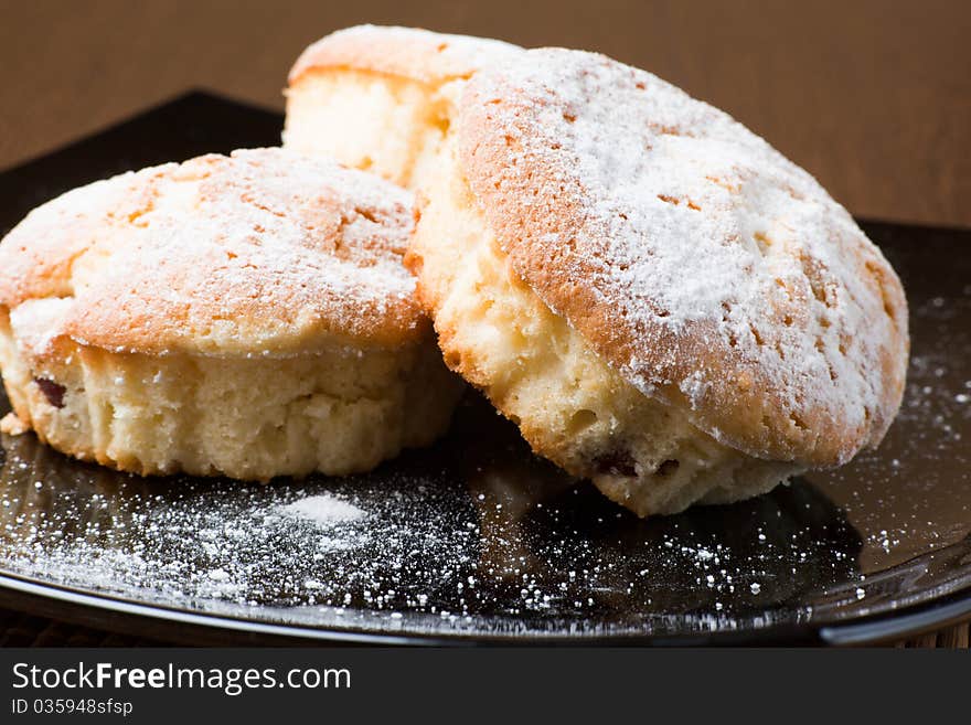 Muffins with a sugar powder on a black plate