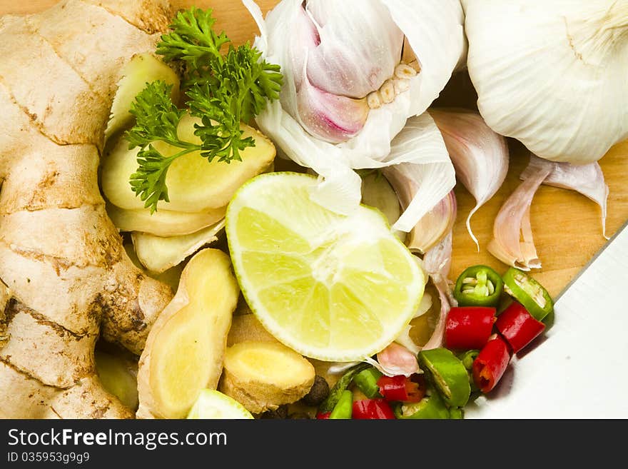 Raw garlic, ginger rhizome, red and green whole fresh chillies with limes. Raw garlic, ginger rhizome, red and green whole fresh chillies with limes