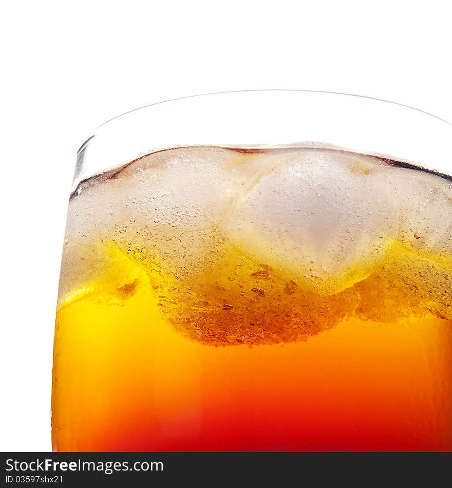 Closeup of fresh cold orange drink in a glass with ice and air bubbles