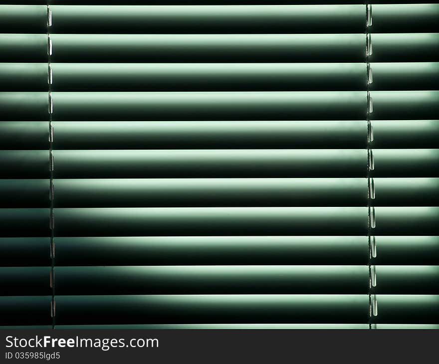 Half-closed louvers stopping morning sunshine through a window