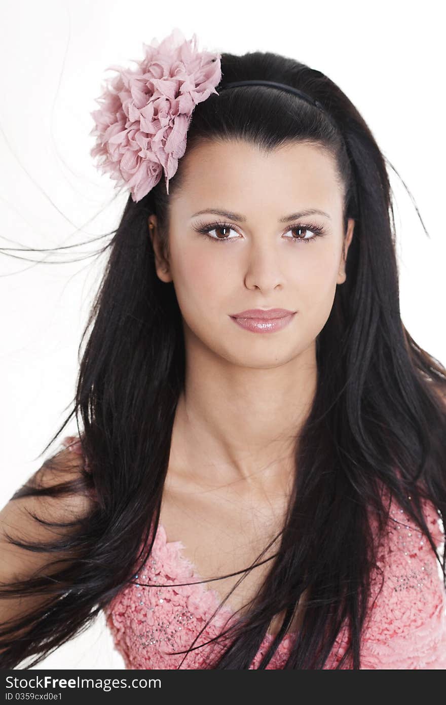 Portrait of young woman in pink dress smiling against white background