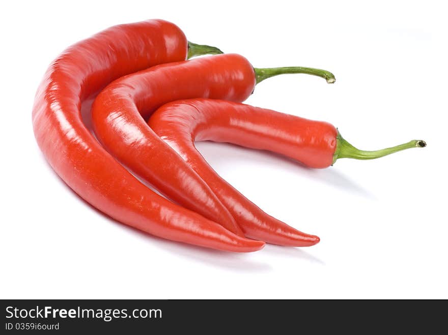 Three red chili peppers on white background. Three red chili peppers on white background.