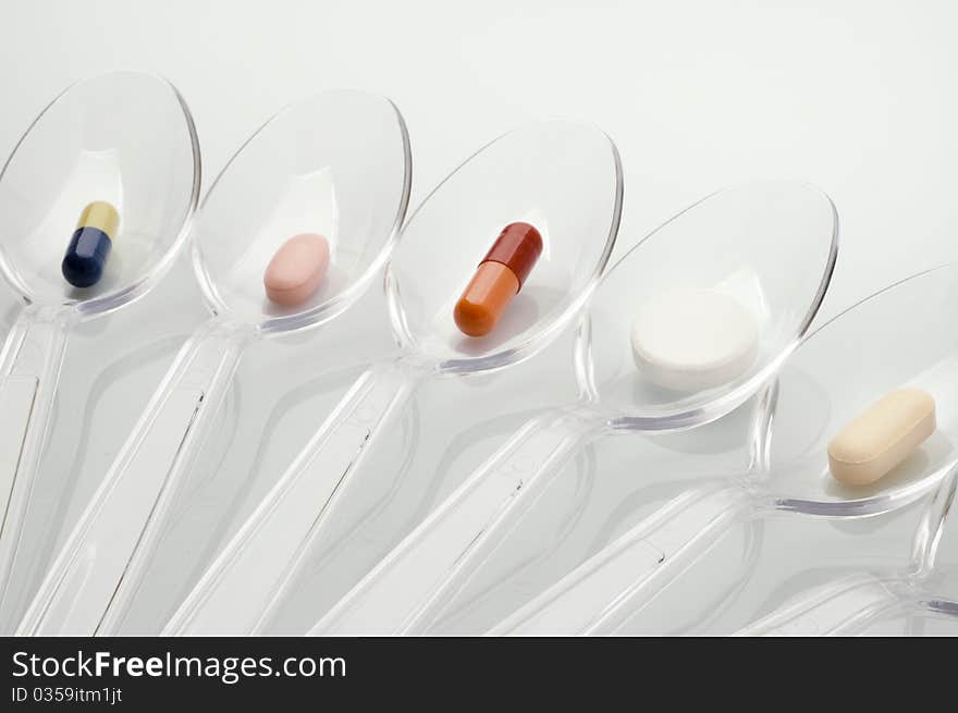 Pills in clear plastic spoons