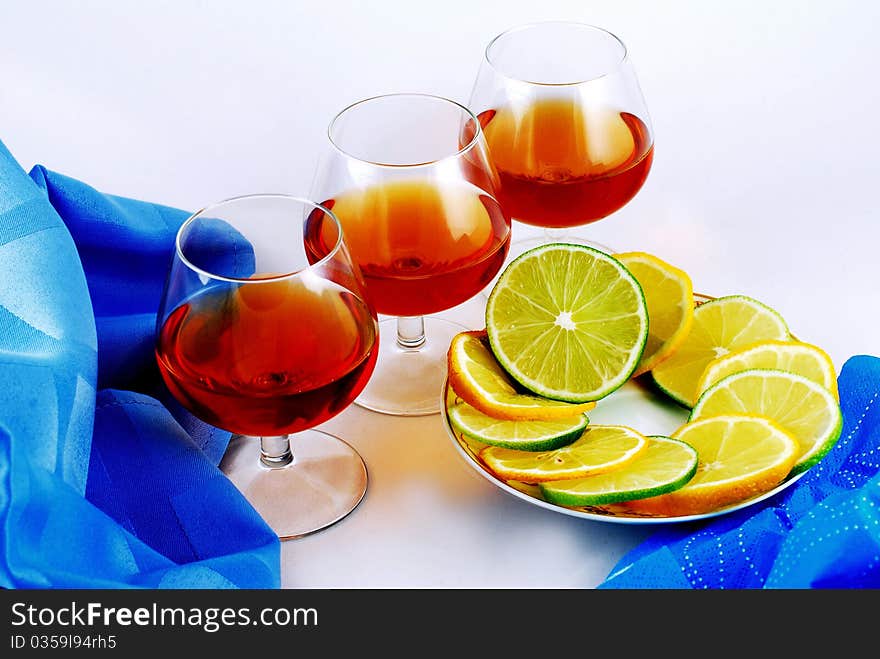 Three glasses of brandy on white background