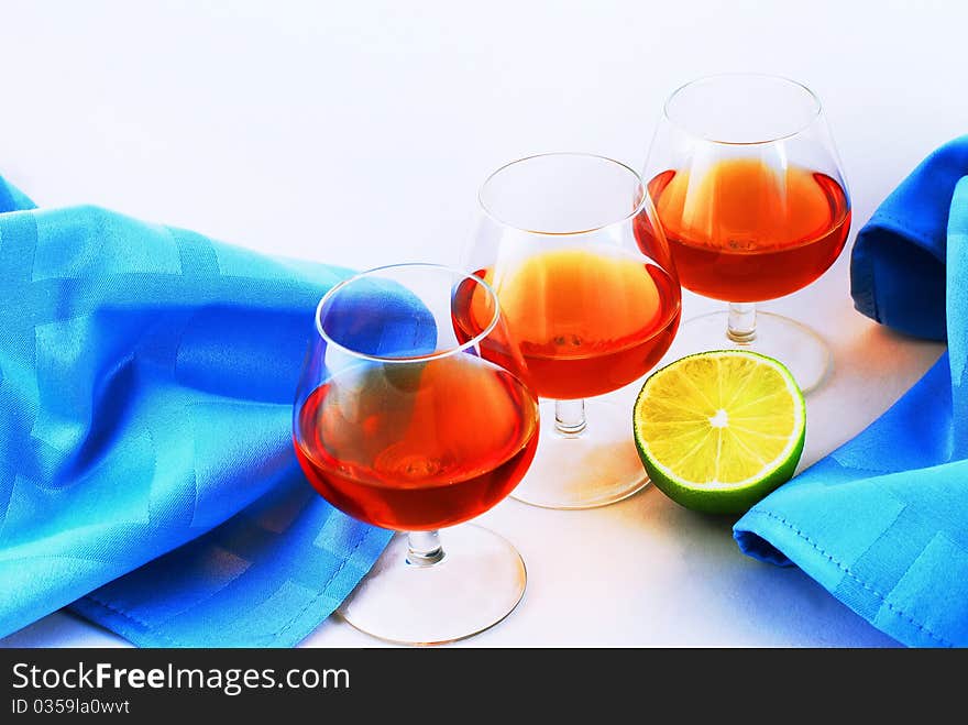 Three glasses of brandy on white background