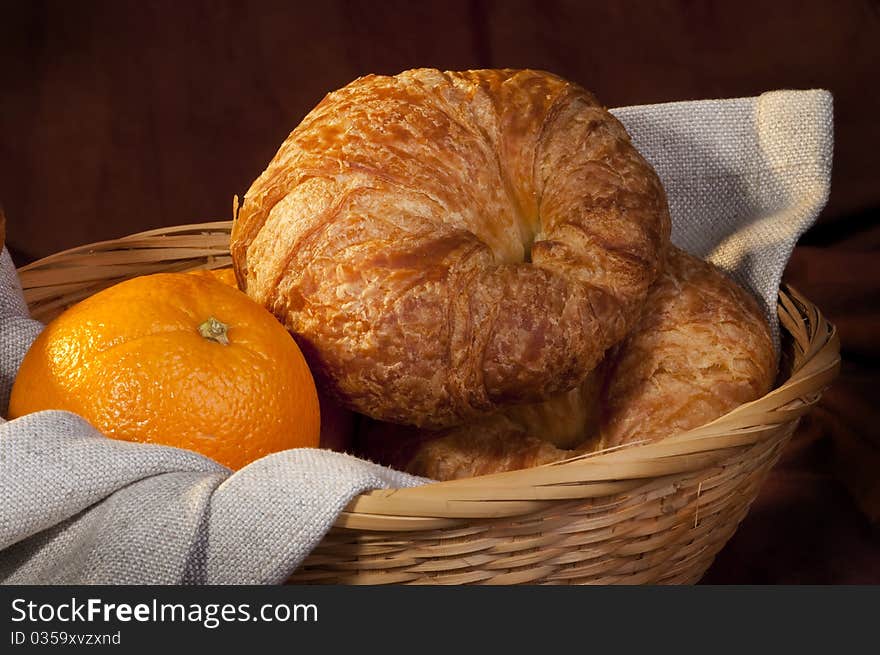 Croissant served for breakfast with orange fruit