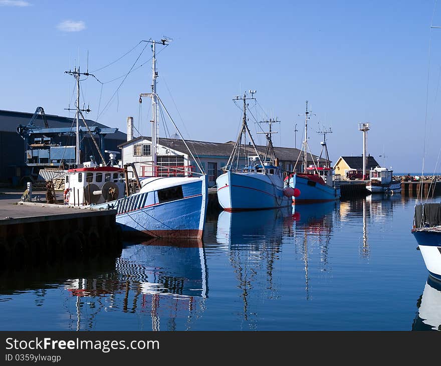 Traditional classical design fishing boats in a port with reflection in the water