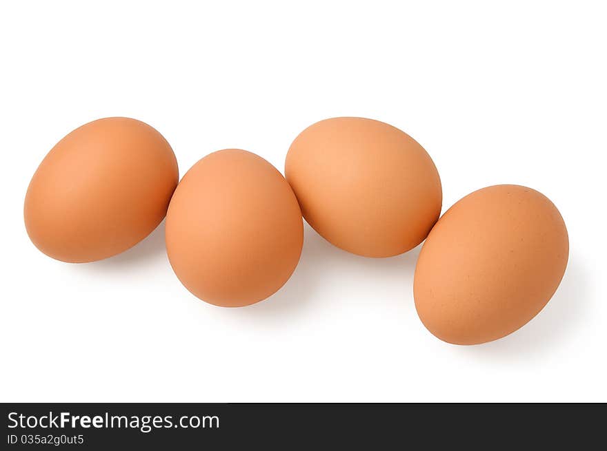 Four brown eggs on a white background