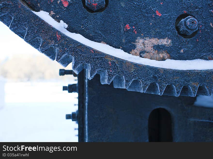 The remained ancient mechanism covered with snow