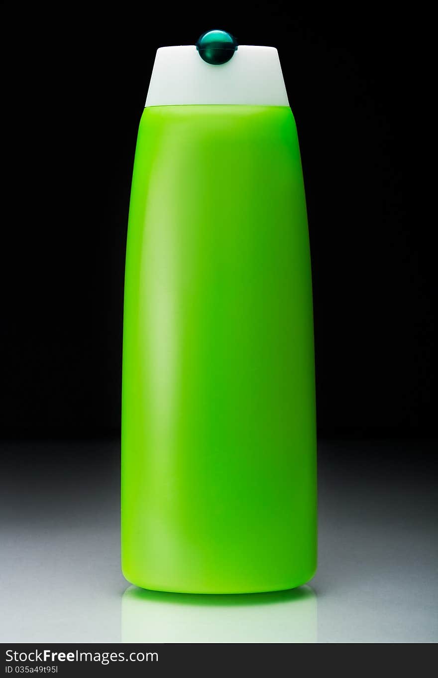 Green shampoo bottle with reflection