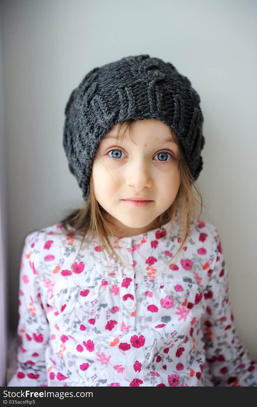 Adorable little kid girl with blue eyes in dark grey knit hat. Adorable little kid girl with blue eyes in dark grey knit hat