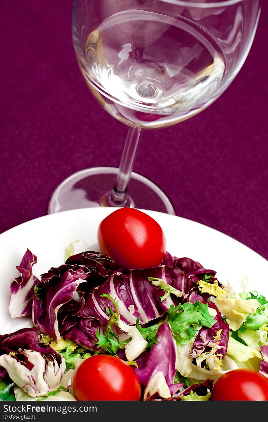 Salad and glass of water in violet