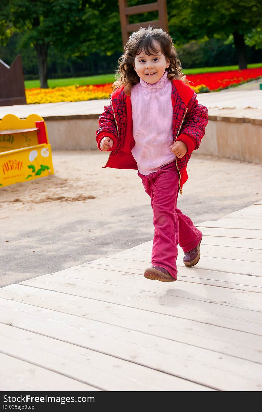 Little girl running in playground in a park