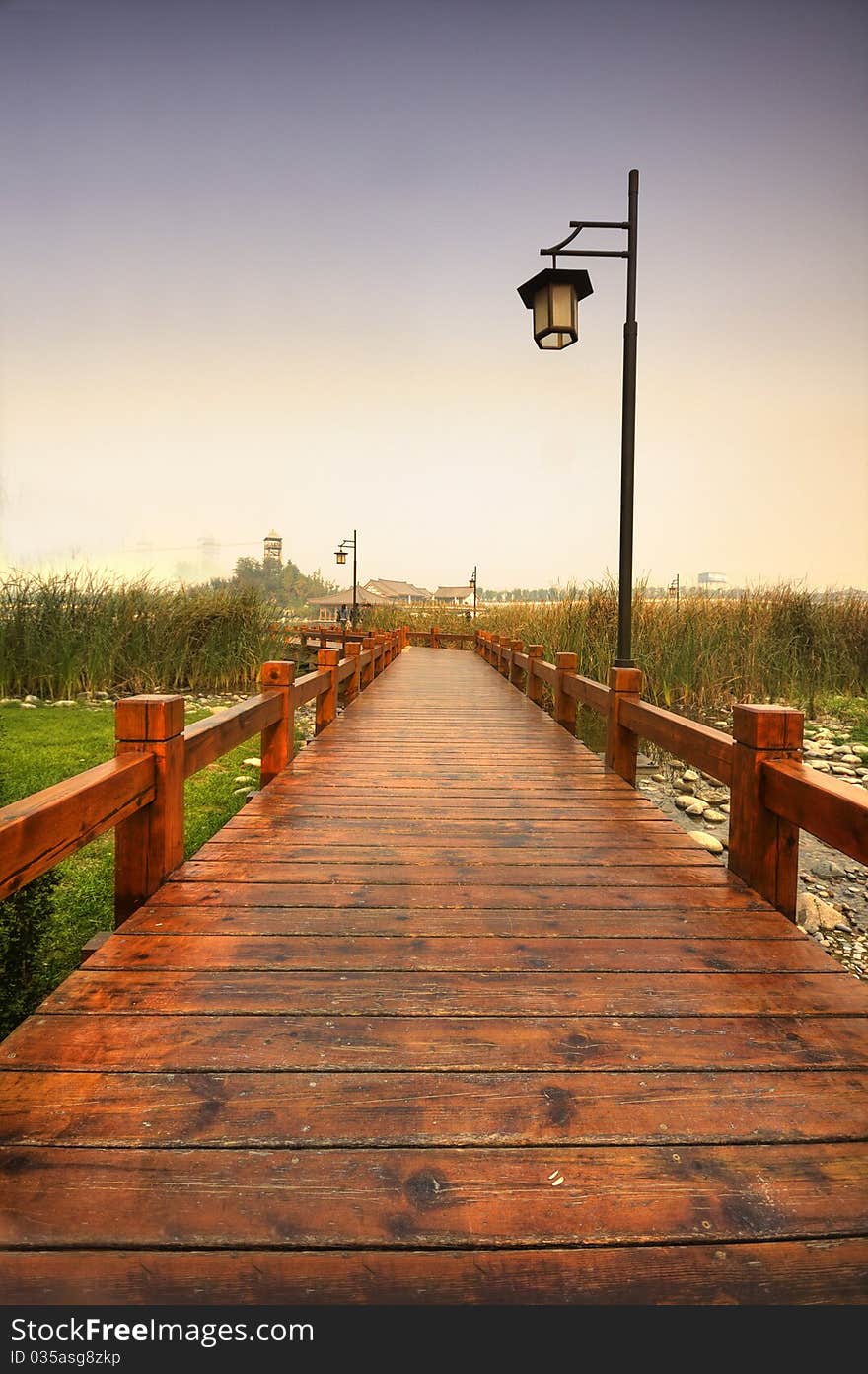 It's a plank road extending with the edge of the Qujiangchi Lake. It's built in the crowed of aquatic plants. The photo was taken when it was raining, the sky was grey and the path was wet. It's a plank road extending with the edge of the Qujiangchi Lake. It's built in the crowed of aquatic plants. The photo was taken when it was raining, the sky was grey and the path was wet.