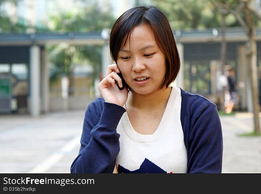 This girl is so busy in talking by phone, with smile on the face. This girl is so busy in talking by phone, with smile on the face.