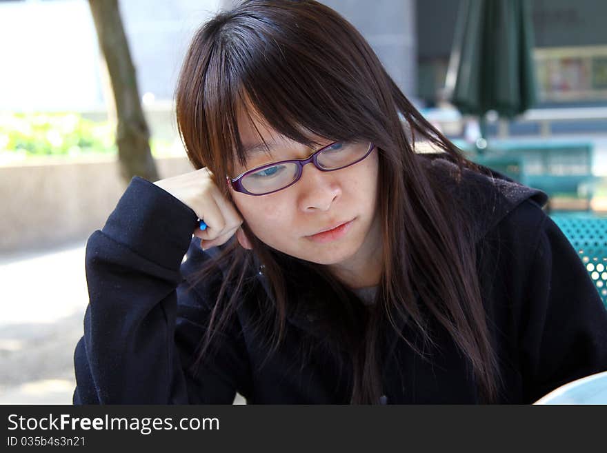 A Chinese girl who is a student, reading books on campus. She is studying hard for exam. A Chinese girl who is a student, reading books on campus. She is studying hard for exam.