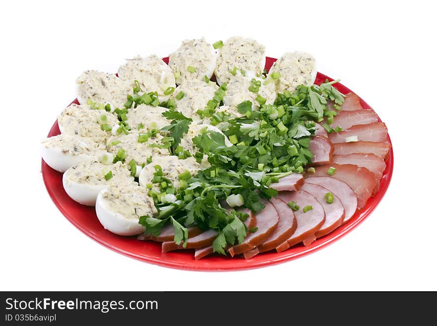 Stuffed eggs and tasty meat with sliced onion and parsley on a white background