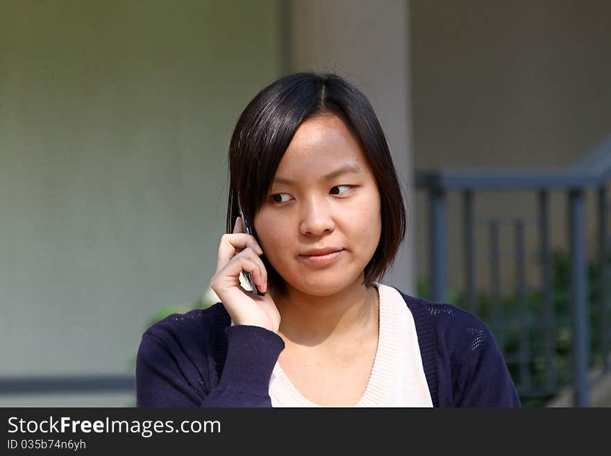 This girl is so busy in talking by phone, with smile on the face. This girl is so busy in talking by phone, with smile on the face.