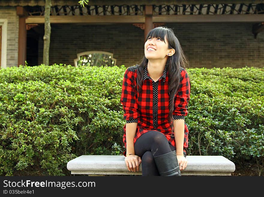 She is waiting in a Chinese style garden with smiling face. She is waiting in a Chinese style garden with smiling face.