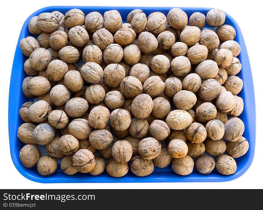 A lot of walnuts on the blue plate isolated over white. Clipping path. A lot of walnuts on the blue plate isolated over white. Clipping path.