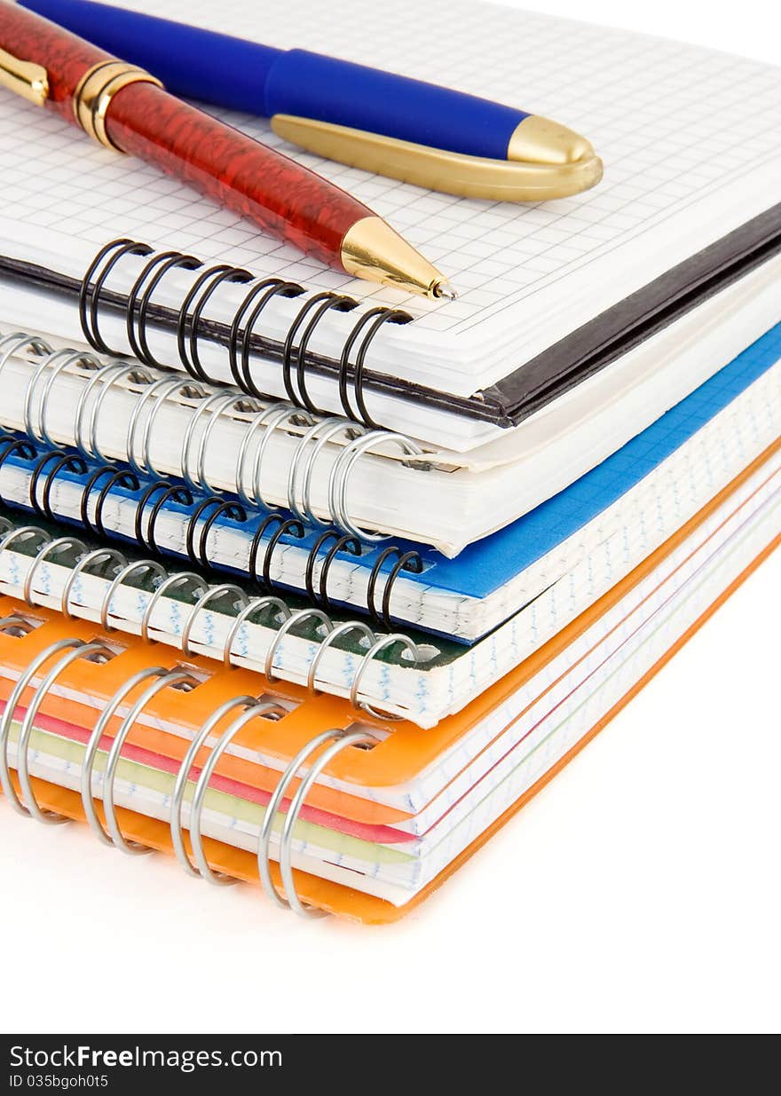 Pens on checked notebook isolated on white background