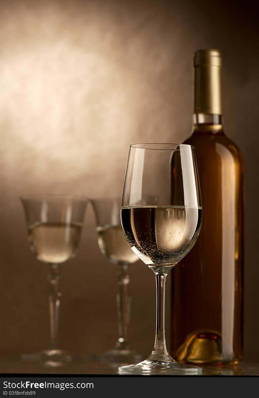 Bottle and glass of wine on a dark background. Bottle and glass of wine on a dark background