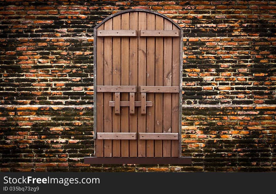 Closed wooden door on vintage brick wall