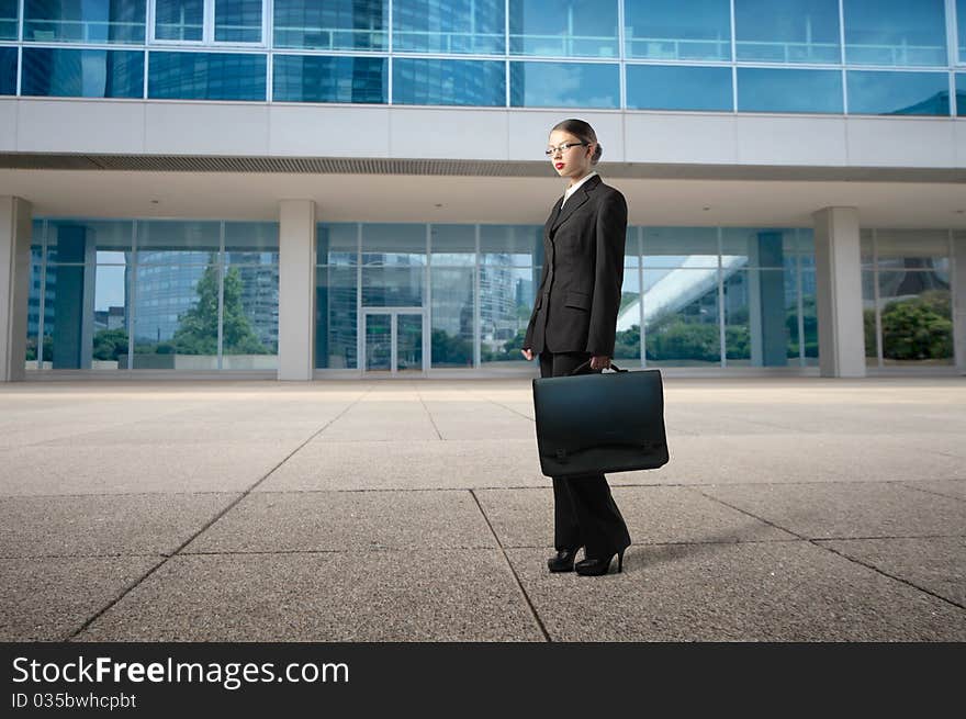 Businesswoman standing in front of elegant office buildings. Businesswoman standing in front of elegant office buildings