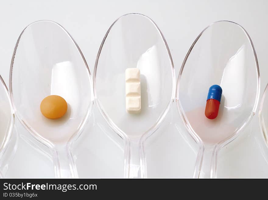 Pills in clear plastic spoons