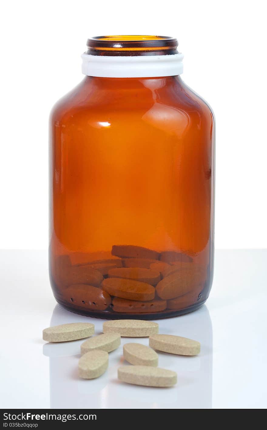 Open pill bottle with medicine spilling out