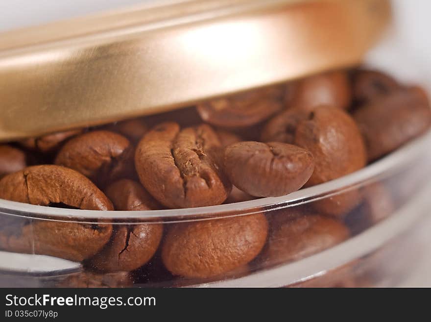 One jar roasted brown coffee beans close-up. One jar roasted brown coffee beans close-up.