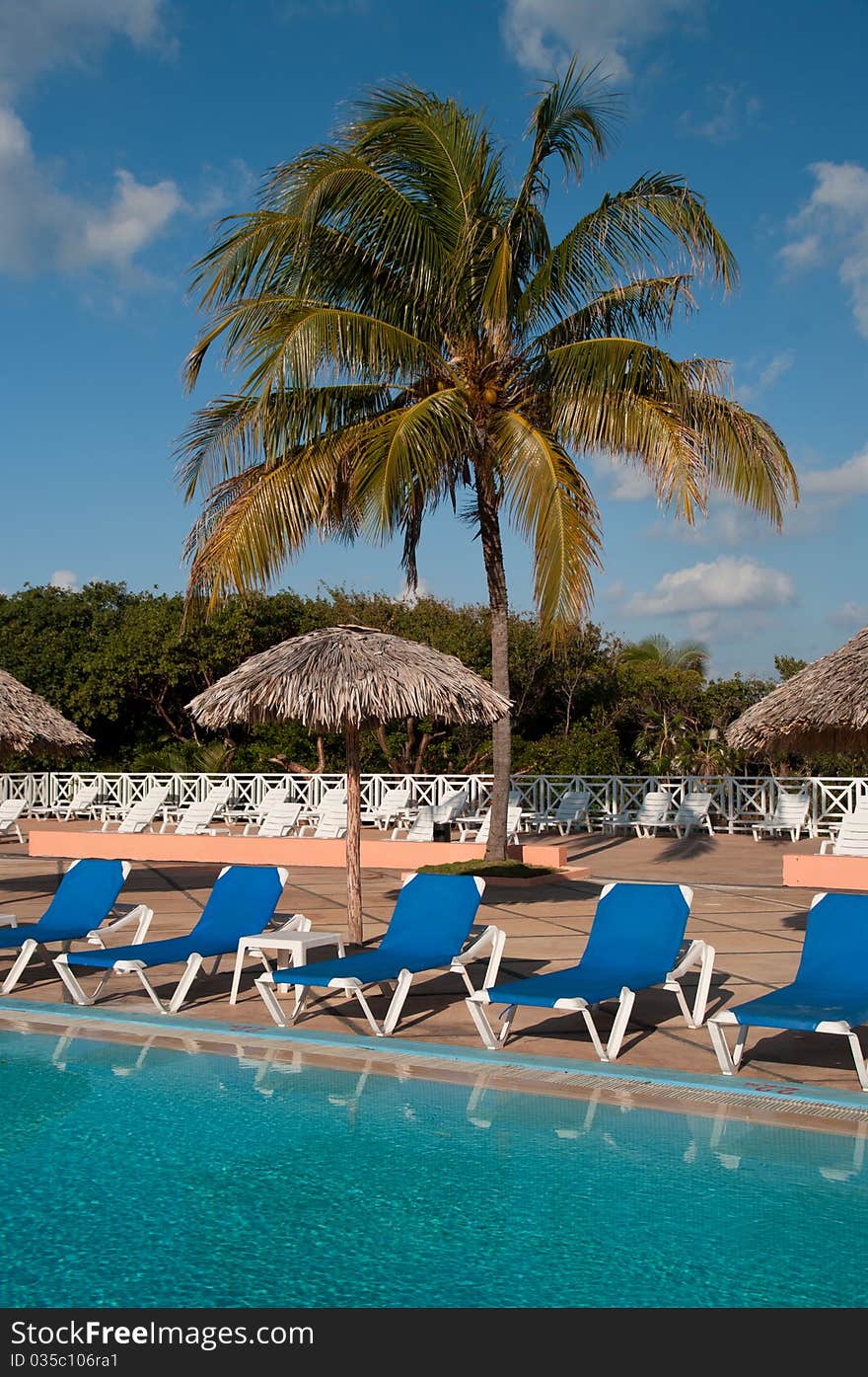 Pool, sun chairs and palm trees in an all inclusive hotel in the tropics. Pool, sun chairs and palm trees in an all inclusive hotel in the tropics