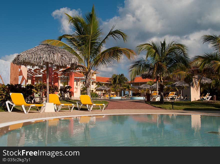 Pool, sun chairs and palm trees in an all inclusive hotel in the tropics. Pool, sun chairs and palm trees in an all inclusive hotel in the tropics