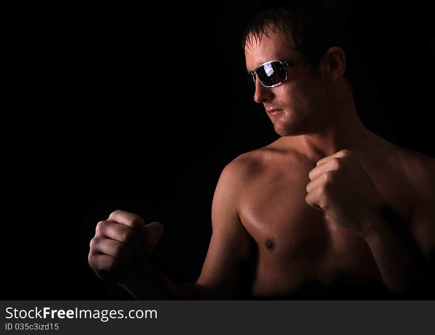 Model in the stance of a boxer ready to fight dripping with sweat. Model in the stance of a boxer ready to fight dripping with sweat