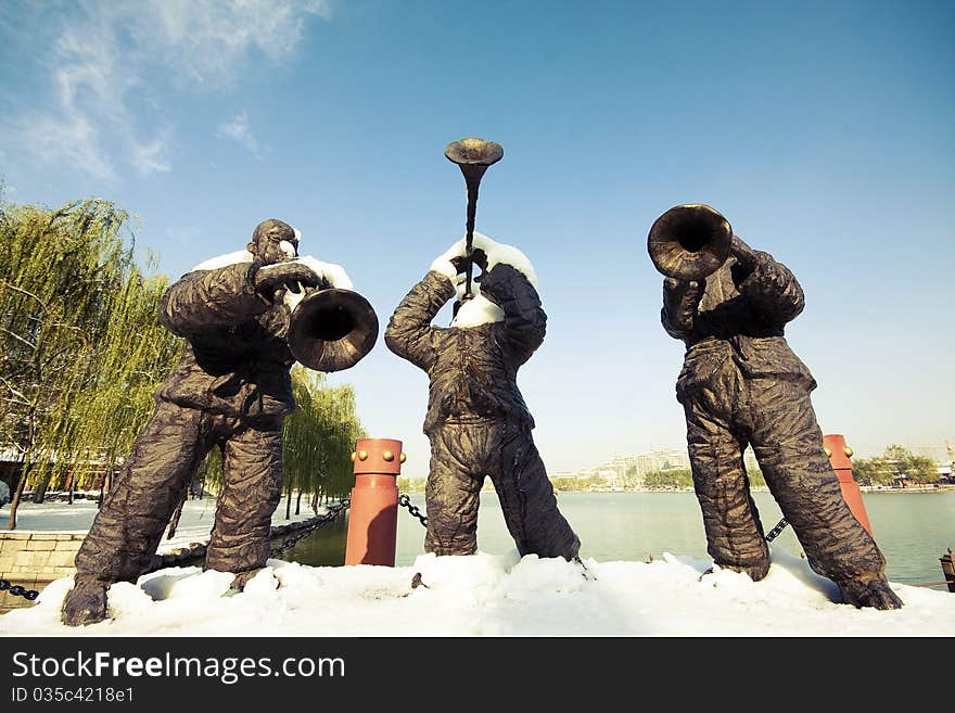 The sculpture stands in Datang Furong Garden of China. There are many folk custom exhibitions. The three men are playing Chinese oboes. The sculpture stands in Datang Furong Garden of China. There are many folk custom exhibitions. The three men are playing Chinese oboes.