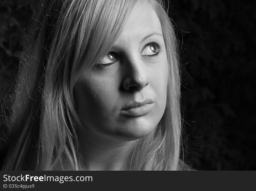 A young girl look up towards the light with black and white background. A young girl look up towards the light with black and white background