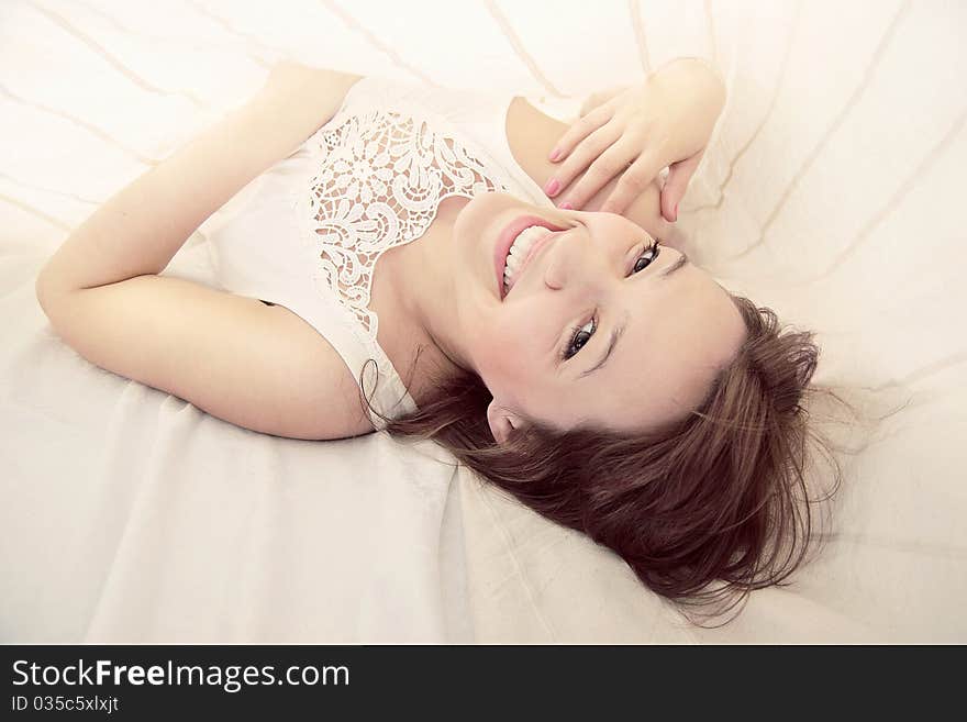 Young beautiful girl in a bed, smiling