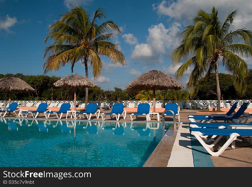 Pool, sun chairs and palm trees in an all inclusive hotel in the tropics. Pool, sun chairs and palm trees in an all inclusive hotel in the tropics