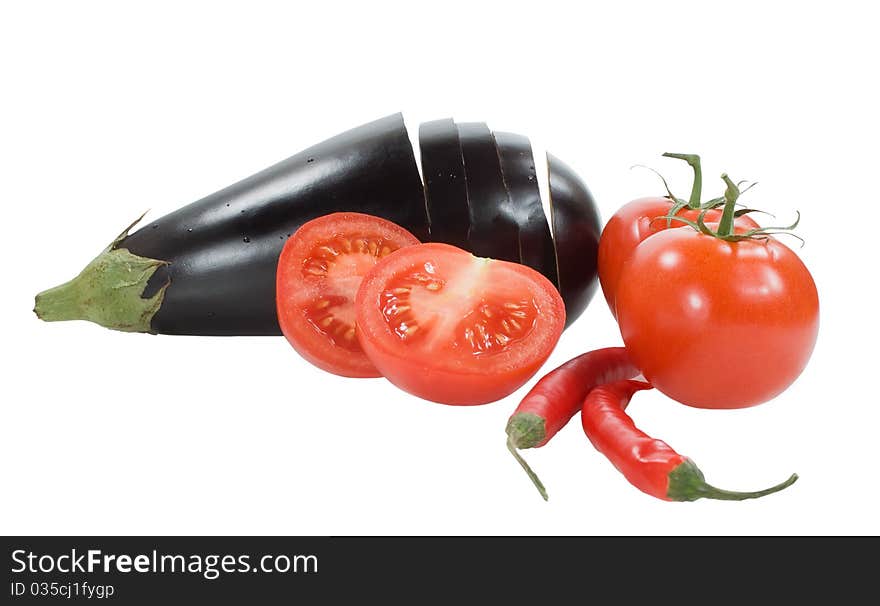 Red tomatoes chilly peppers and aubergine on the white background