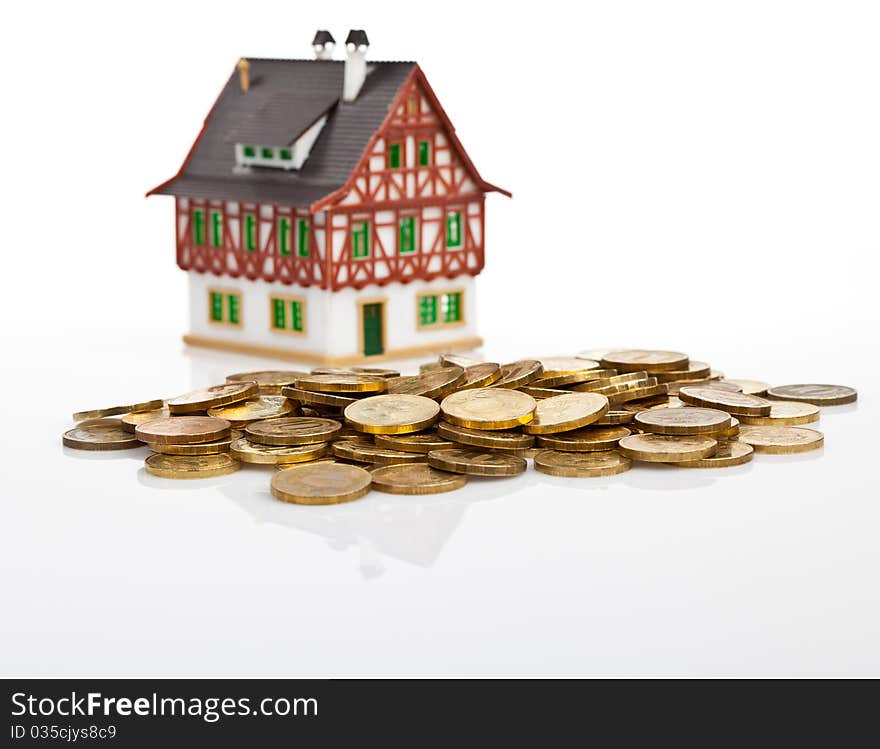 Miniature house with the coins on white. Miniature house with the coins on white