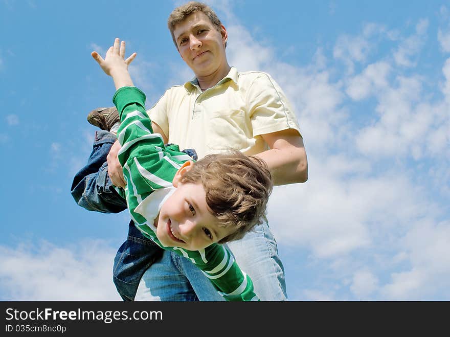 Father and son against the blue sky